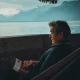 Person sitting on a bench looking at a lake