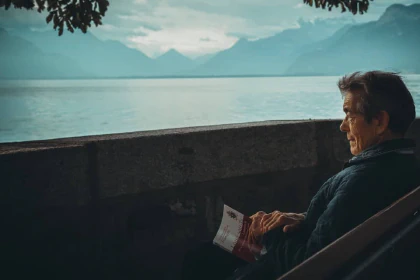 Person sitting on a bench looking at a lake