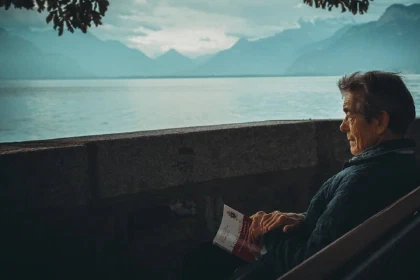 Person sitting on a bench looking at a lake