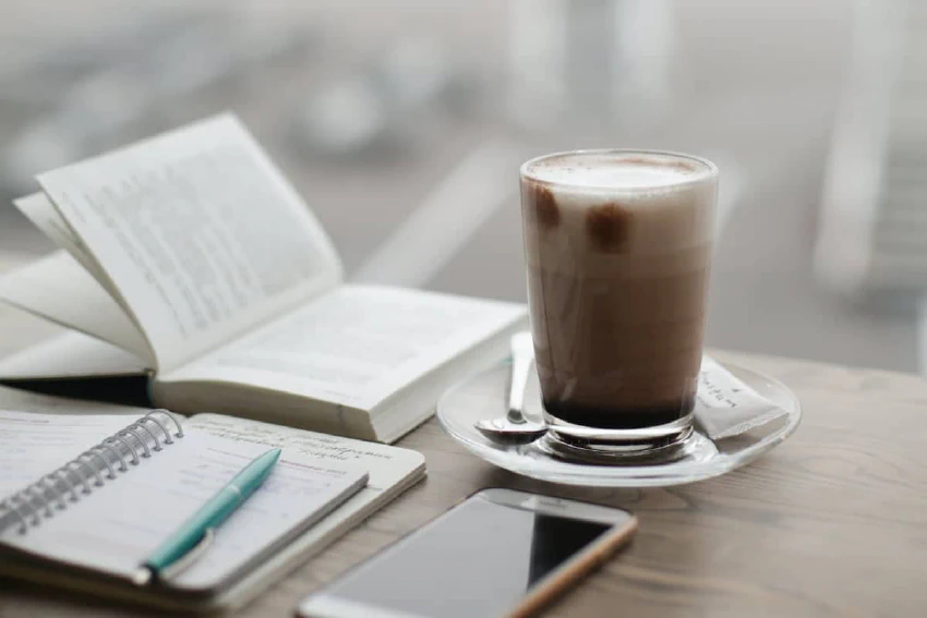 Coffee, phone, book, and notes