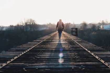 Person walking on a railroad bridge
