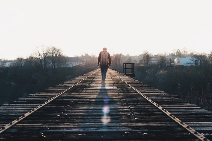 Person walking on a railroad bridge