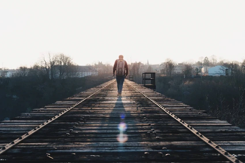 Person walking on a railroad bridge